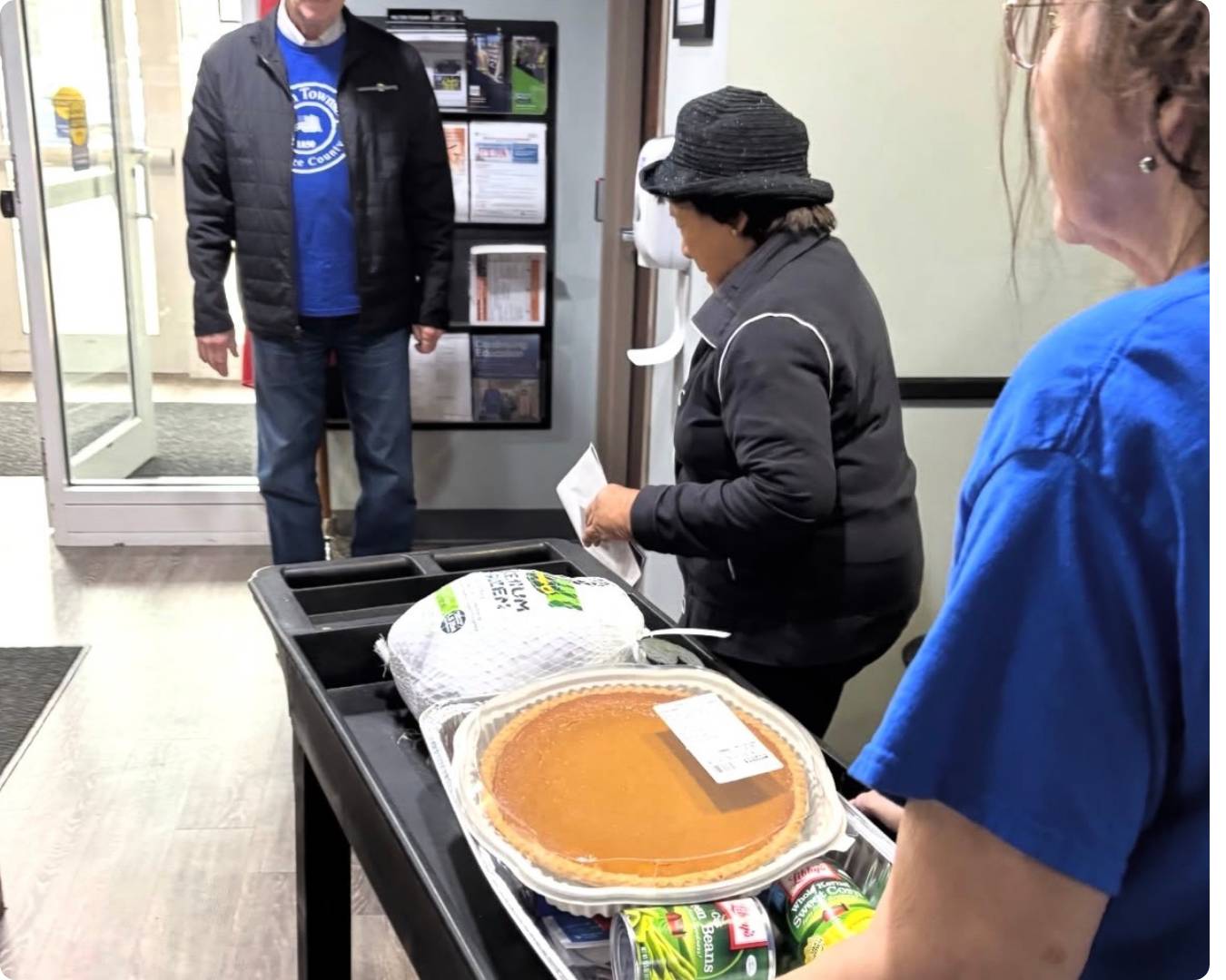 Food Pantry Client being assisted with a cart full of food out the door